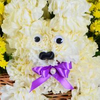 Puppy in a Basket of Flowers